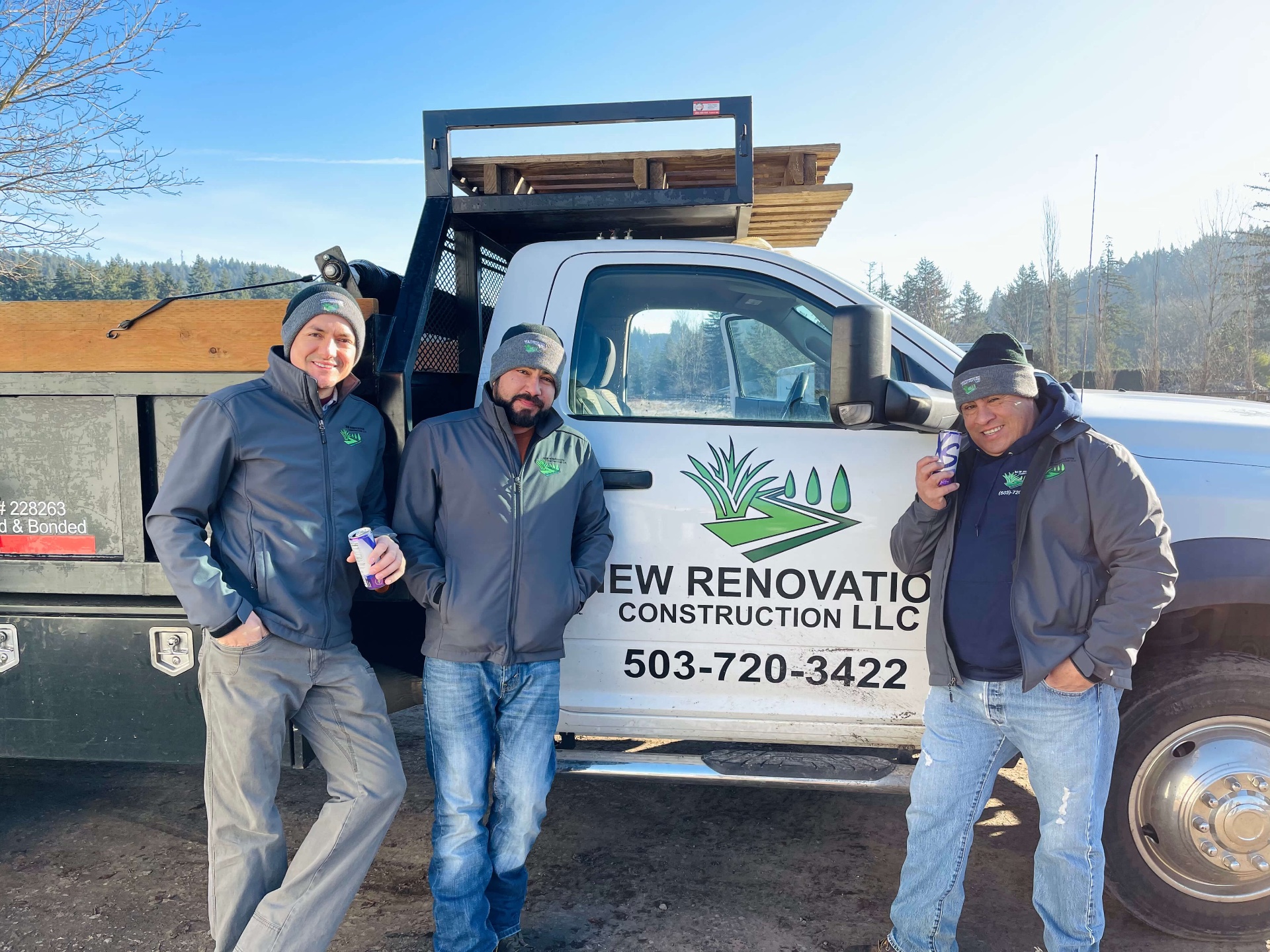 Carlos, Alberto and Esteban — the owners of New Renovation Construction LLC — standing in front of the company truck.